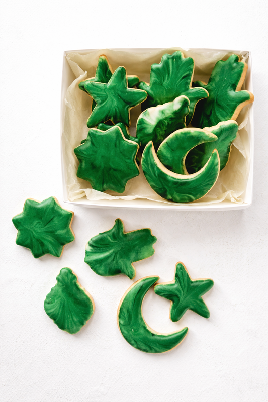 Coffret biscuits décorés lune et étoiles vertes avec biscuits artisanaux disposés autour de la boîte – création gourmande Ramadan