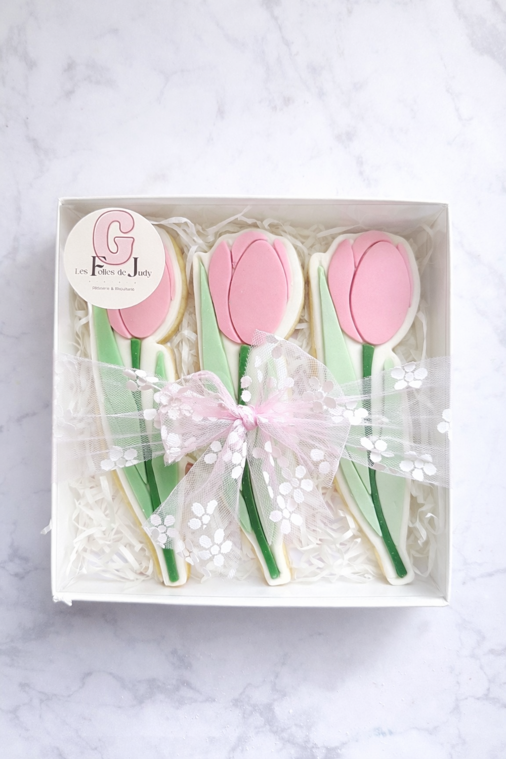 Coffret de 3 biscuits décorés artisanaux en forme de tulipes roses et vertes, présentés dans une boîte élégante prête à offrir.