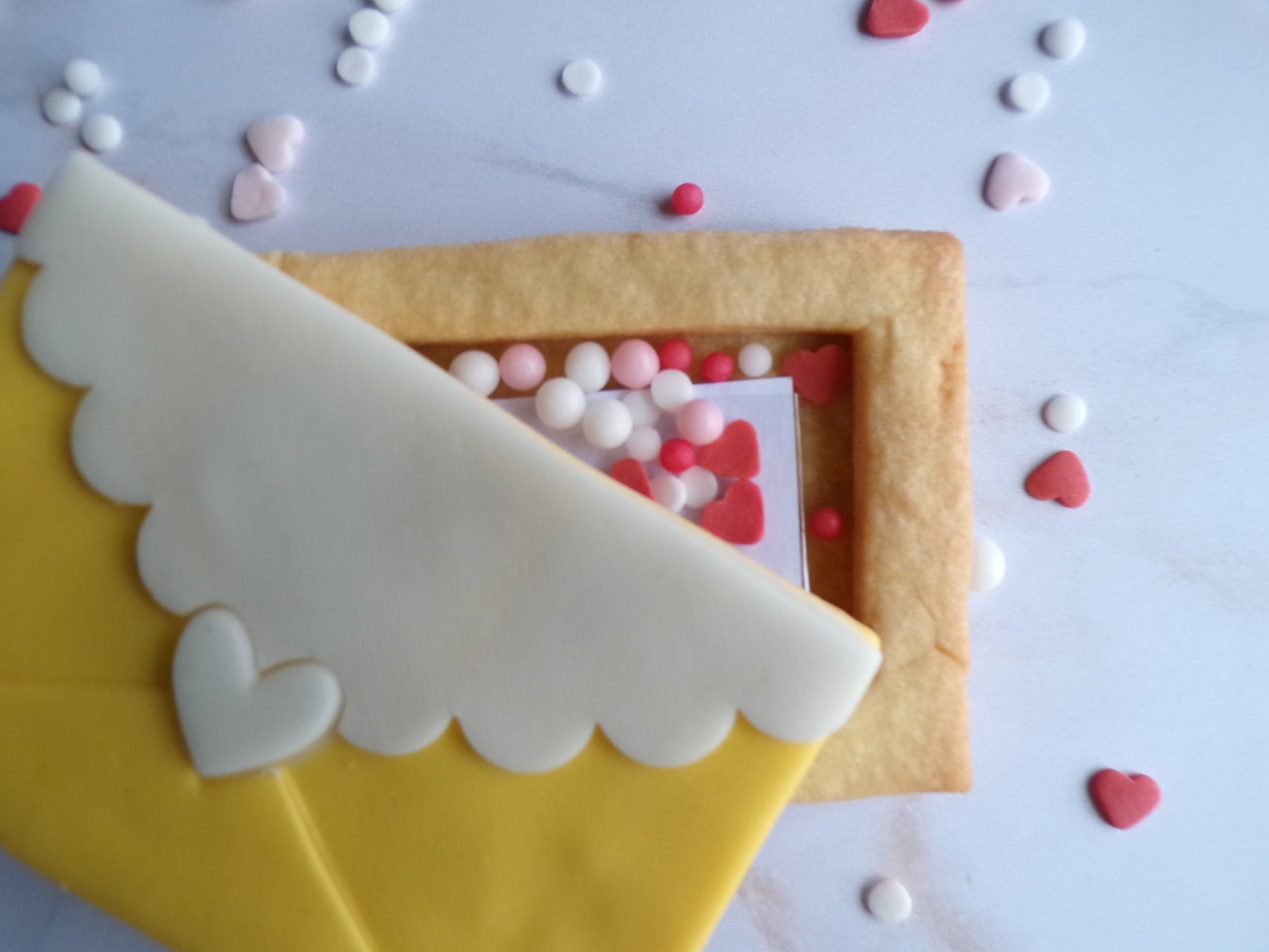 biscuit sablé en forme d'enveloppe jaune et blanc. il y un message surprise à l'intérieur