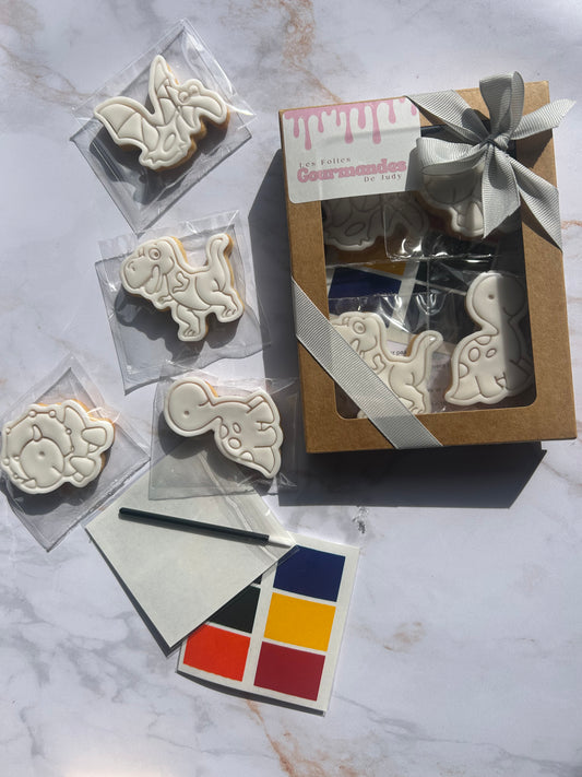 Biscuits dino décorés en pâte à sucre blanche avec plaquette de peinture alimentaire et pinceau jetable