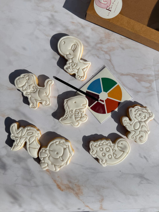 Biscuits dino décorés en pâte à sucre blanche avec plaquette de peinture alimentaire et pinceau jetable