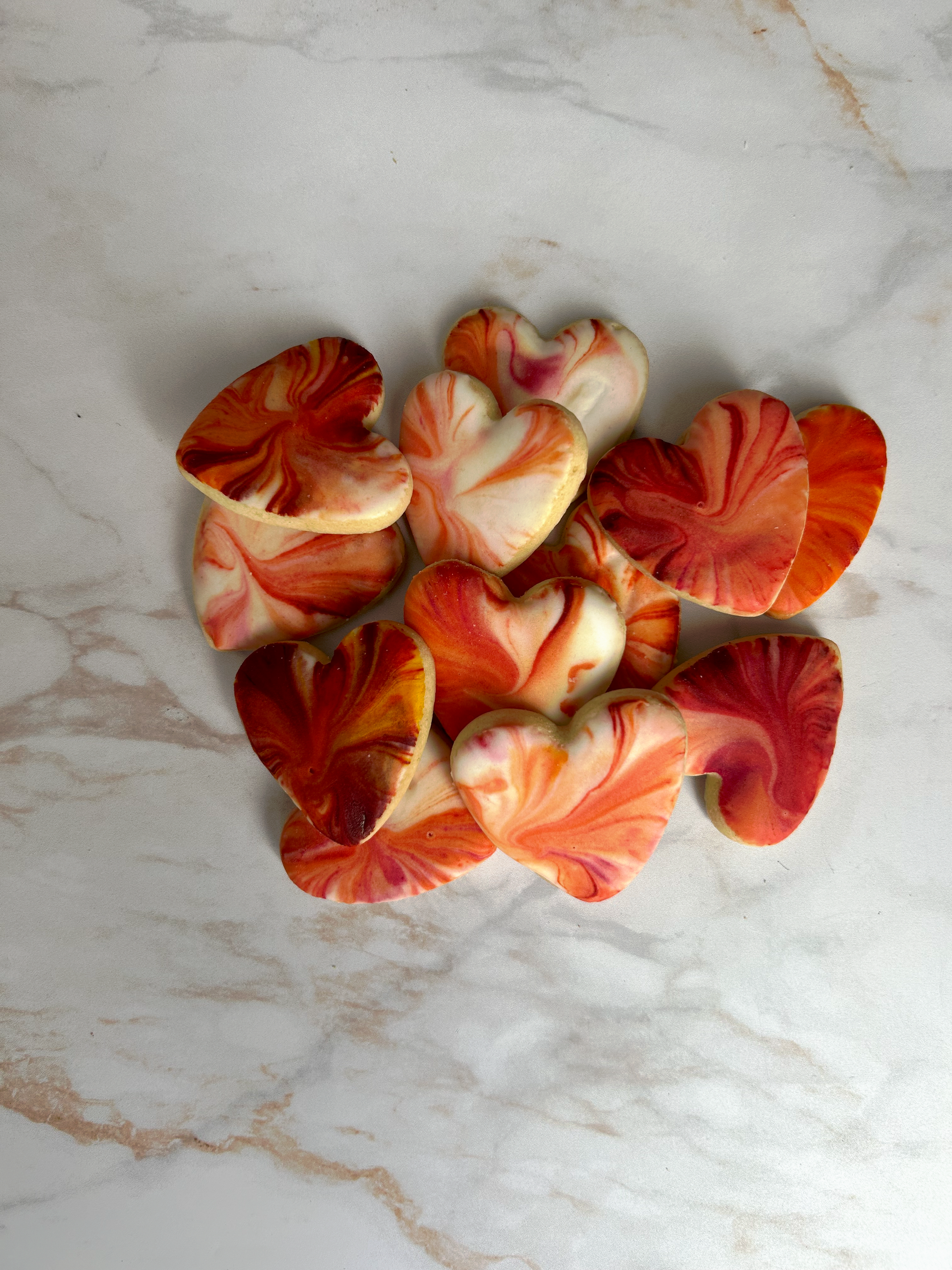 Biscuit cœur marbré rouge et ivoire au glaçage royal, décor artisanal.

Détail d’un biscuit sablé en forme de cœur, glaçage royal marbré.

Lot de biscuits cœurs décorés, création artisanale Les Folies Gourmandes de Judy.