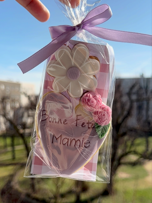 Mini coffret Fête des Grand-Mères avec biscuit cœur personnalisé Bonne fête Mamie, décor floral en pâte à sucre, emballé avec ruban rose par Les Folies Gourmandes de Judy.